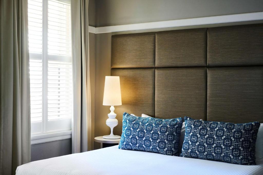 a bedroom with a bed with a large headboard at Hotel Kurrajong Canberra in Canberra
