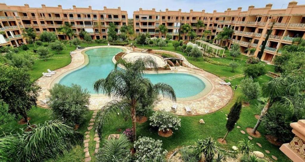 een uitzicht over een zwembad in een resort bij Sublime appartement dans résidence prestigieuse in Marrakesh