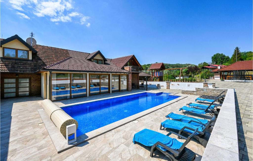 basen z leżakami i dom w obiekcie Cozy Home In Donja Batina With Outdoor Swimming Pool w mieście Donja Batina