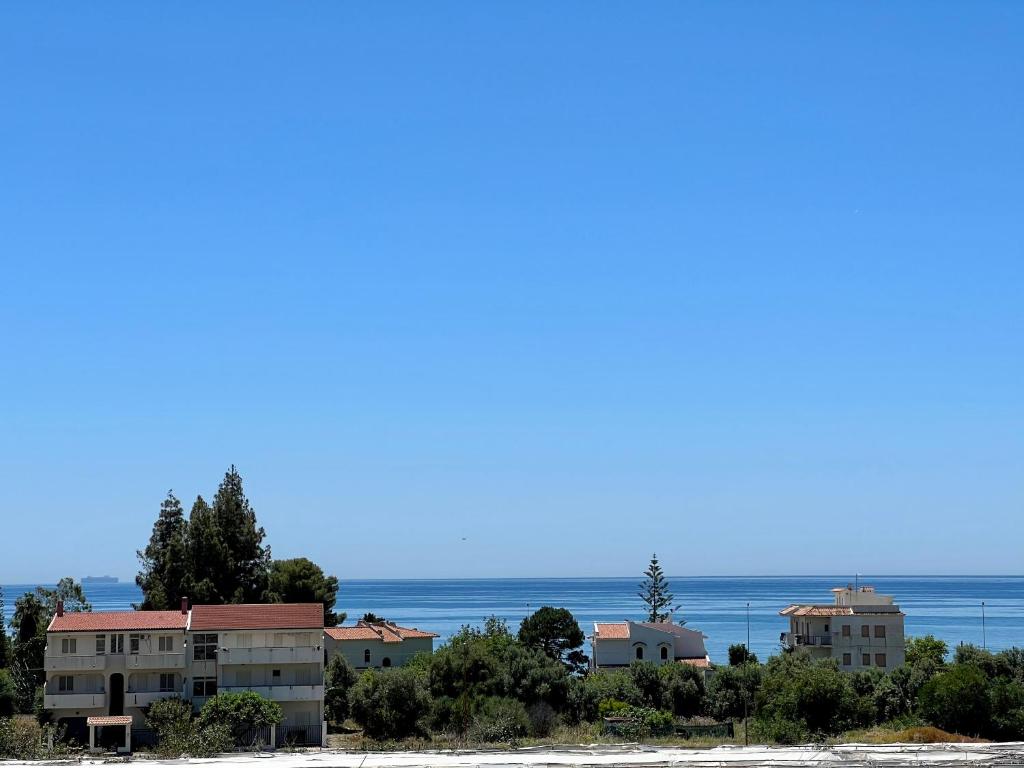 a group of buildings on a beach with the ocean in the background at Casa Celestina in Marina di San Lorenzo