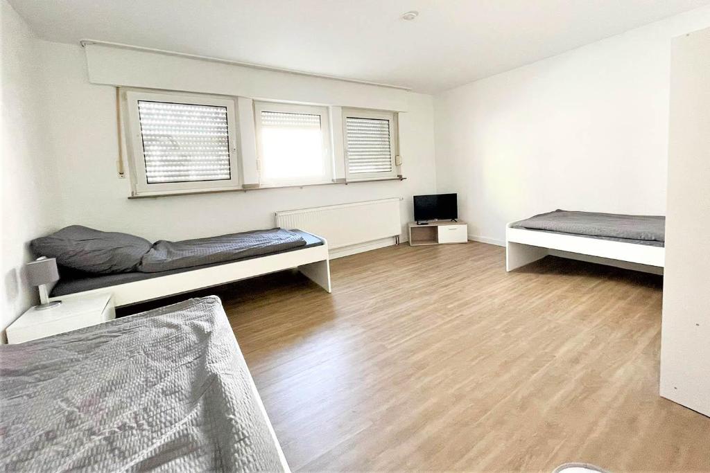 - un salon avec 2 lits et une télévision dans l'établissement Equipped Apartment in Düren, à Düren