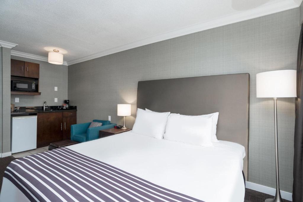 a hotel room with a bed and a kitchen at Sandman Hotel Revelstoke in Revelstoke