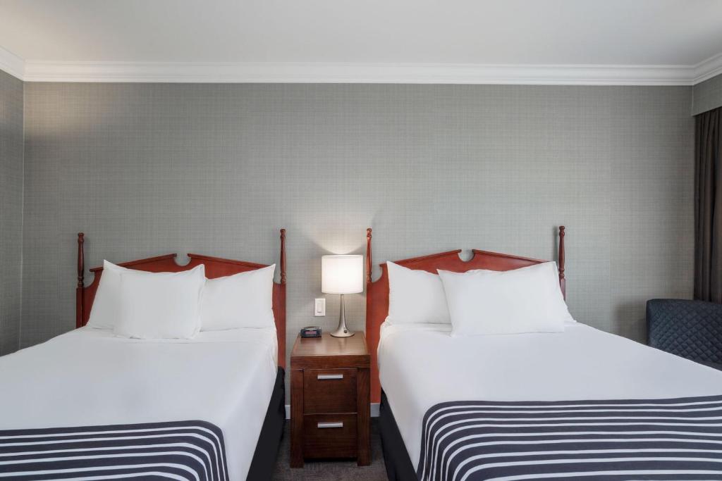 a hotel room with two beds and a chair at Sandman Hotel Revelstoke in Revelstoke