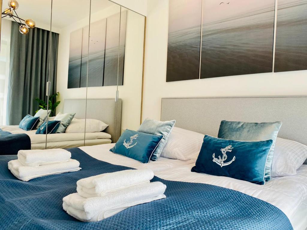 um quarto com 2 camas com almofadas azuis e brancas em HO!HOUSE SHELLTER ROGOWO em Rogowo