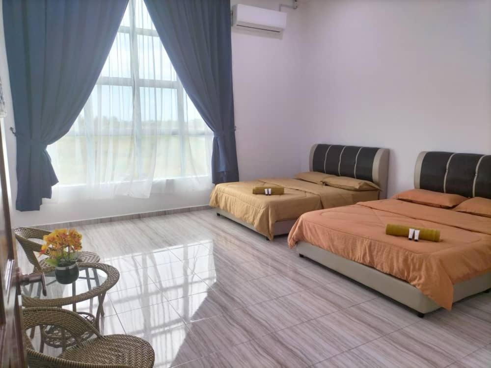 1 dormitorio con 2 camas, mesa y sillas en Kangar Jaya Lodging, en Kangar