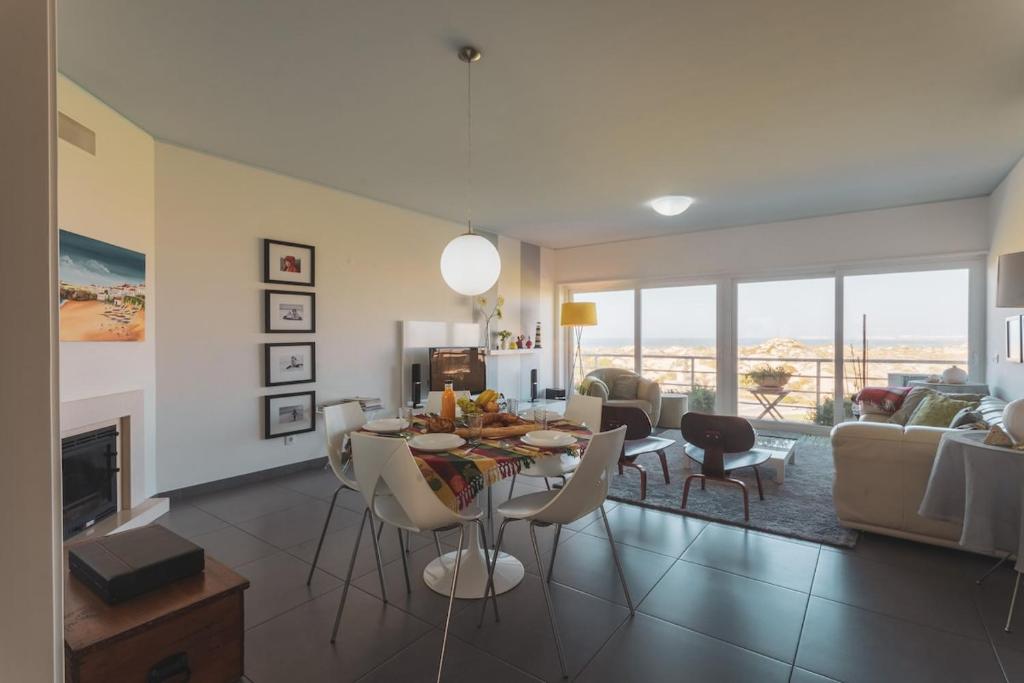 ein Wohnzimmer mit einem Tisch und Stühlen sowie ein Wohnzimmer in der Unterkunft Best Houses 38 - Praia Residences in Peniche