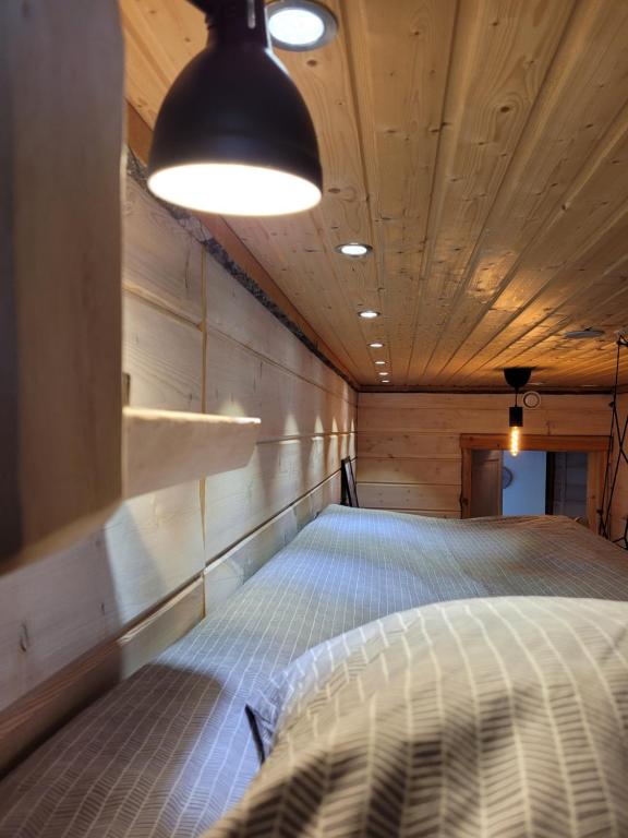 a bed in a room with a wooden ceiling at Chalet Päämaja Rovaniemi in Rovaniemi