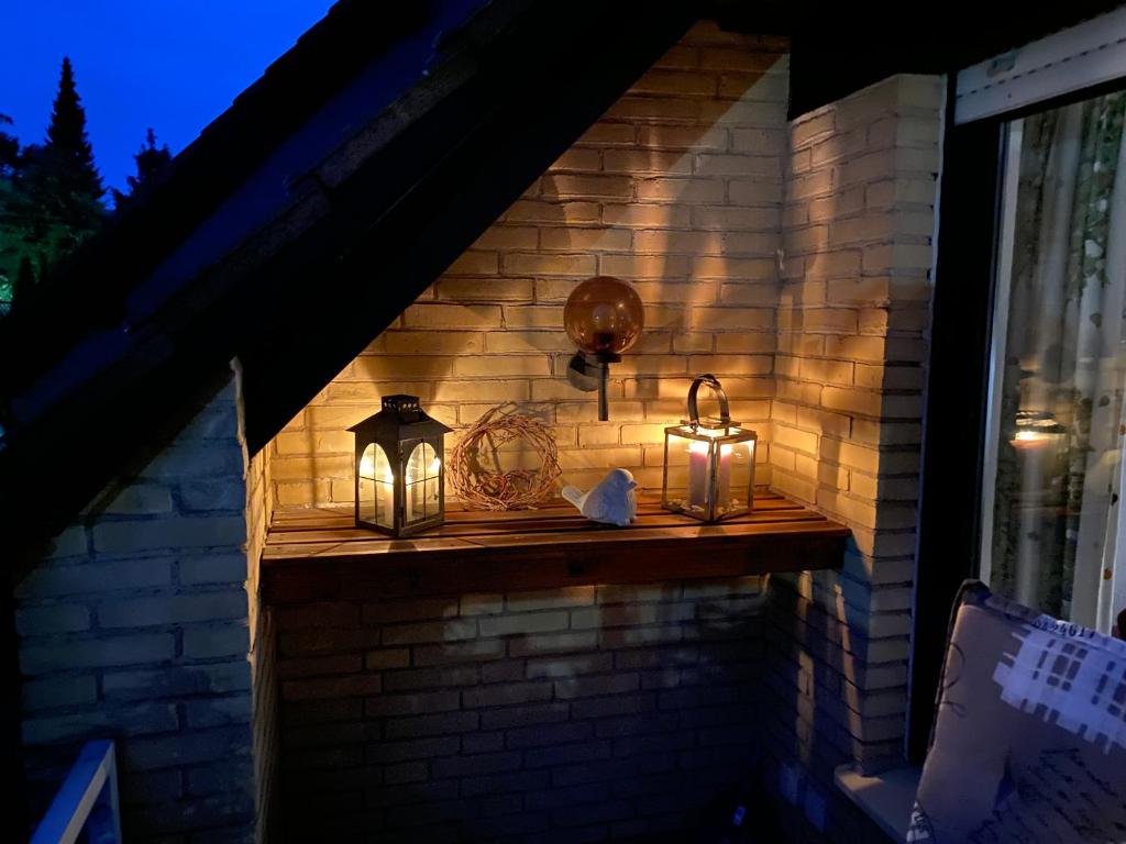 un mur en briques avec lanternes et lumières sur un grand livre dans l'établissement Gipfel Lounge, à Hahnenklee
