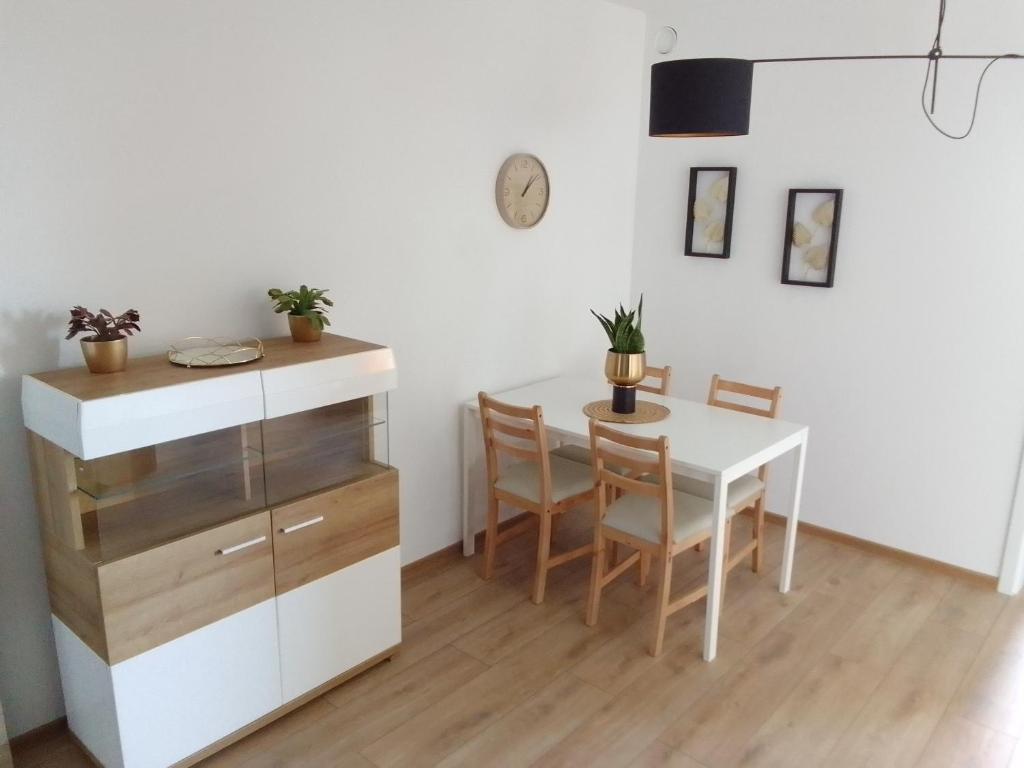 a dining room with a white table and chairs at Complex Apartamenty - Golden in Koszalin
