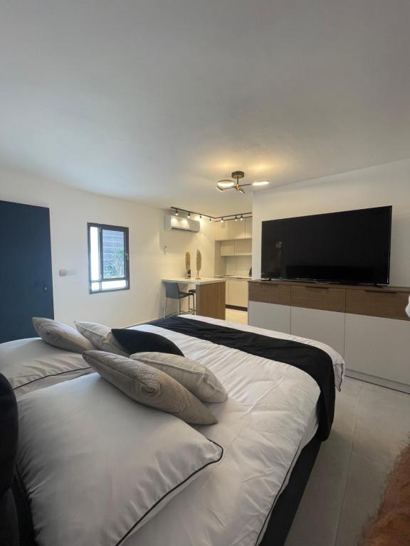 rooms 48 في إيلات: غرفة نوم بسرير مع مخدات وتلفزيون بشاشة مسطحة