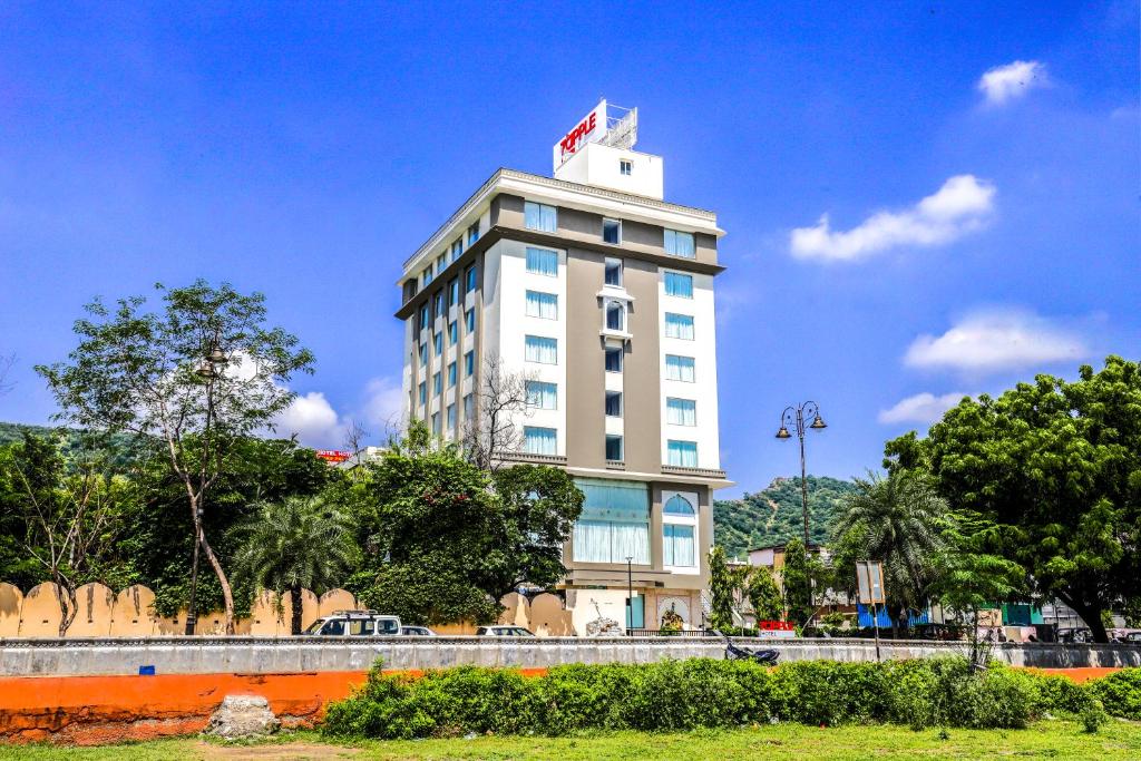 a tall white building with a flag on top of it at 7 Apple Hotel Jal Mahal, Jaipur in Jaipur