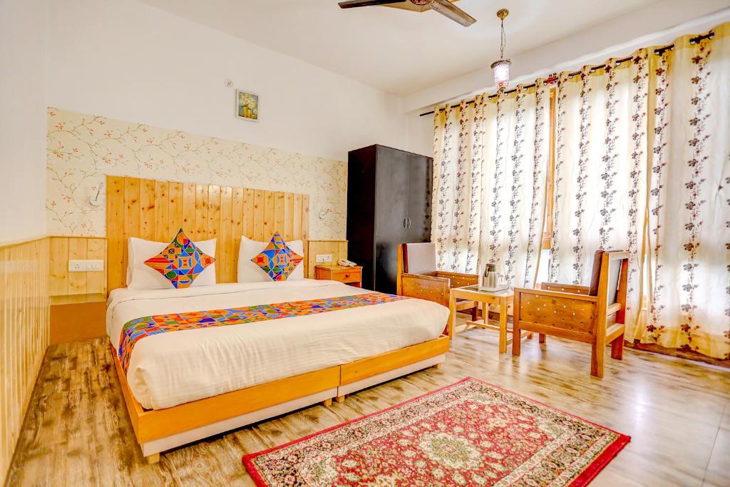 um quarto com uma cama, uma mesa e cadeiras em FabHotel The Countryside B and B em Manali