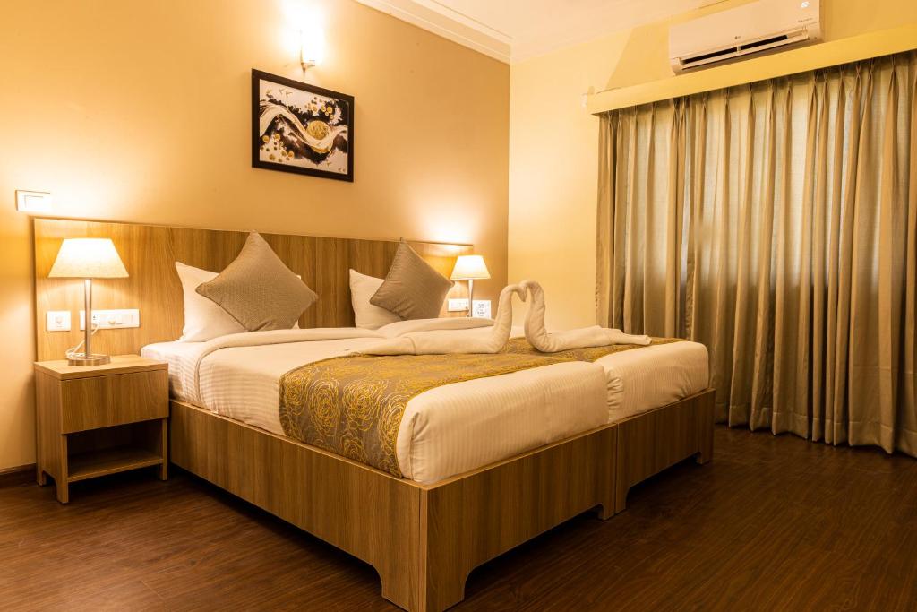 Postel nebo postele na pokoji v ubytování Starlit Suites Tirupati