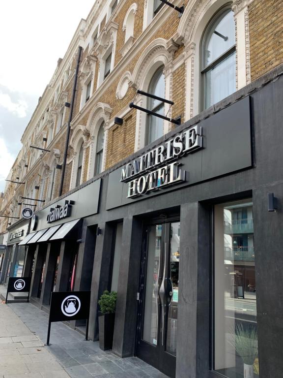 una tienda frente a un edificio con un cartel. en Maitrise Hotel Maida Vale - London en Londres