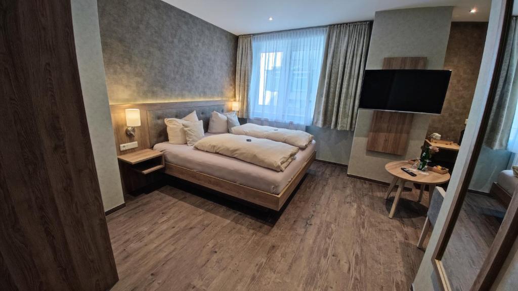 a hotel room with a bed and a flat screen tv at Hotel Garni "Zur Alten Post" in Willingen