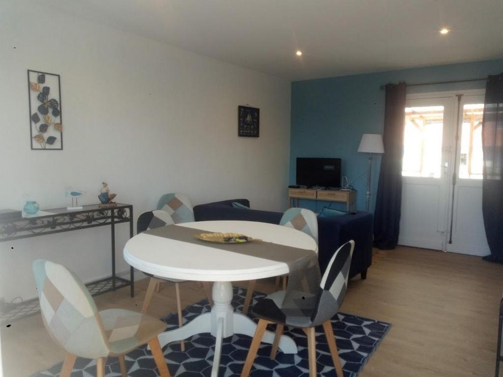 salon z białym stołem i krzesłami w obiekcie La charmante Cayolaise w mieście Cayeux-sur-Mer