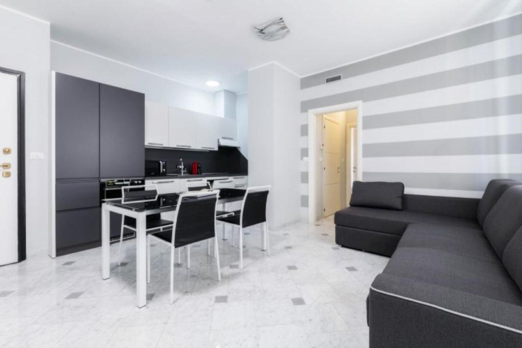 uma sala de estar com um sofá, uma mesa e cadeiras em Appartamento Giulia - Alassio em Alassio