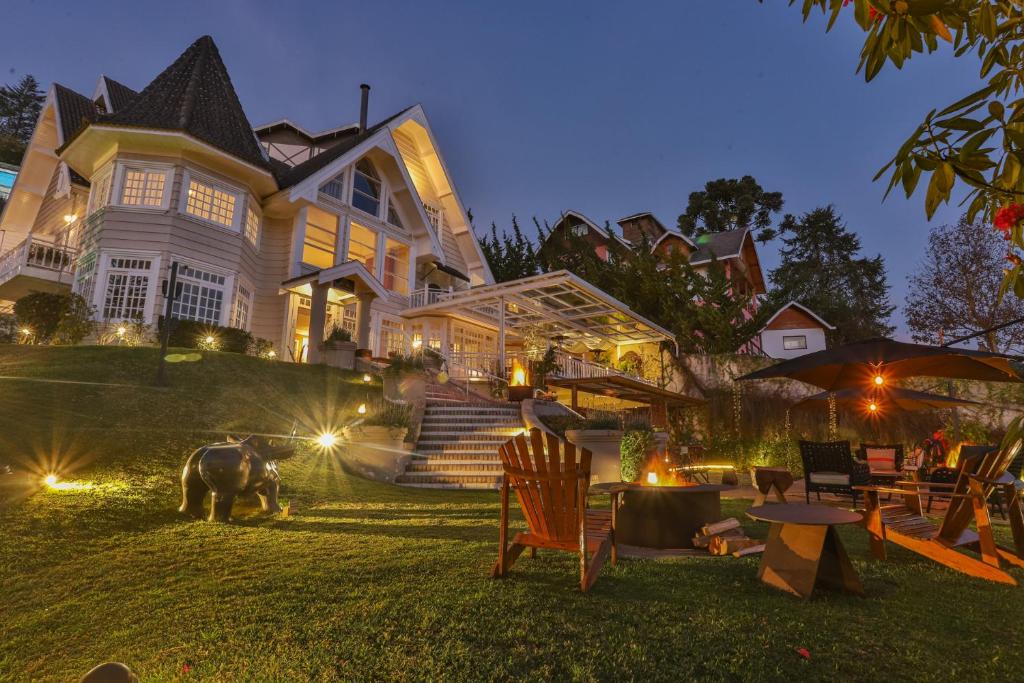 a large house with a horse standing in the yard at Secreto Boutique Hotel in Campos do Jordão