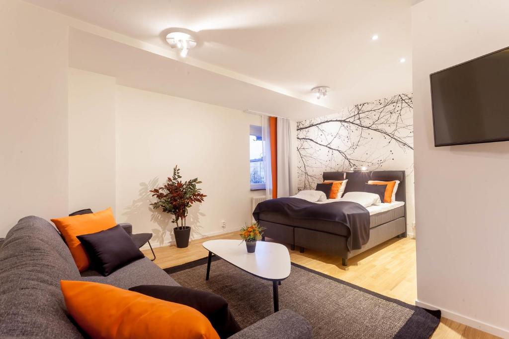 a living room with a couch and a bed at ApartDirect Solna in Solna