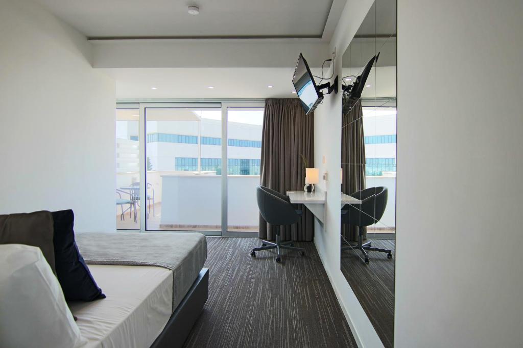 een slaapkamer met een bed en een bureau met een computer bij Phaedrus Living: Luxury Suite Nicosia 504 in Nicosia