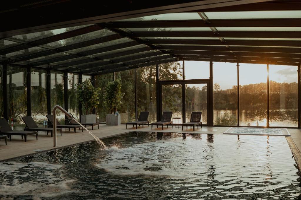 a swimming pool with chairs and a water fountain at Olandia in Kwilcz