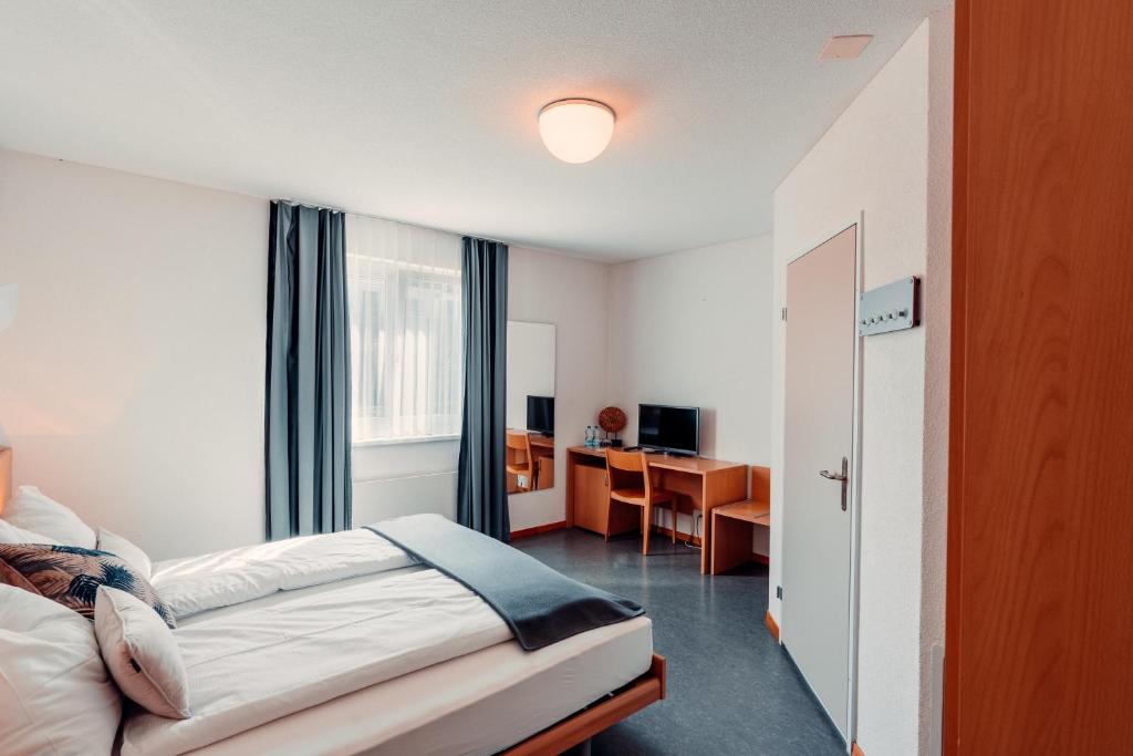 Postel nebo postele na pokoji v ubytování Hotel Rössli Luterbach