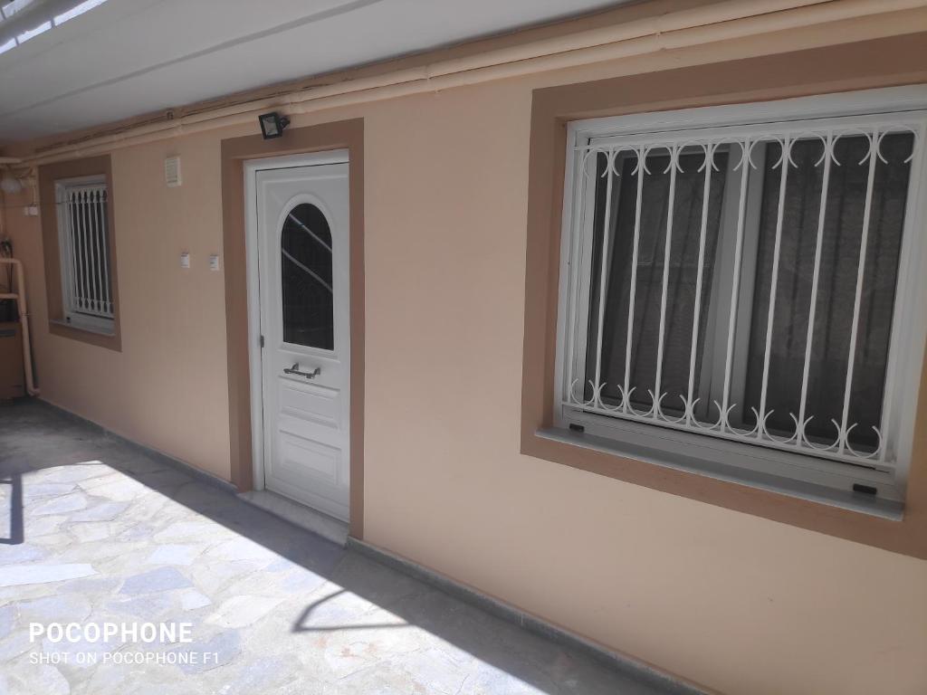 Habitación con puerta y ventana con barrotes en Κεντρικό, άνετο και ζεστό διαμέρισμα, en Kamena Vourla