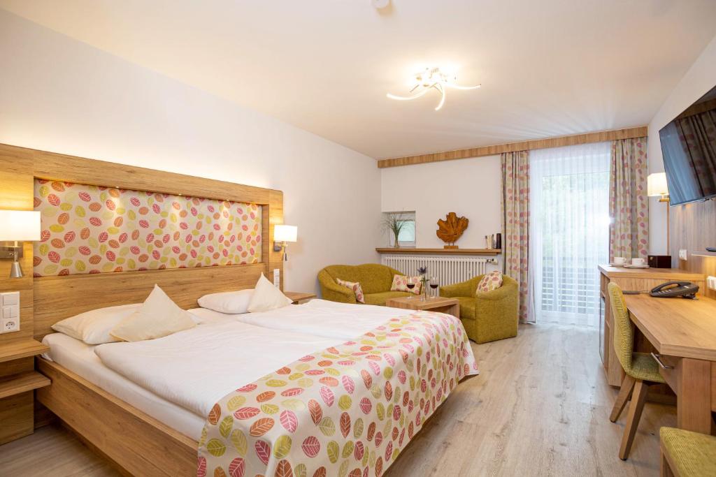 Pokój hotelowy z łóżkiem i biurkiem w obiekcie Hotel Chrysantihof w mieście Bad Birnbach