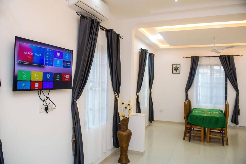 um quarto com uma televisão de ecrã plano na parede em William Ofori-Atta Fie em Acra