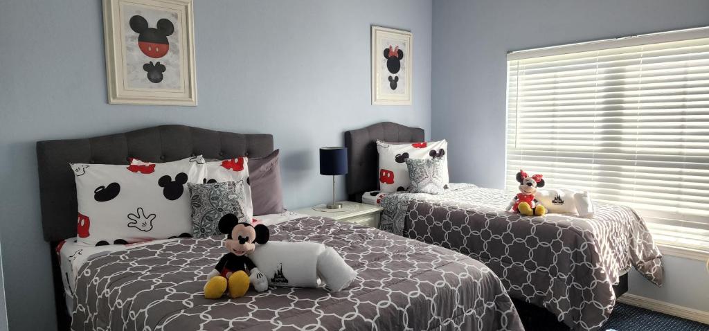 a bedroom with two beds with stuffed animals on them at My Home in Orlando in Kissimmee