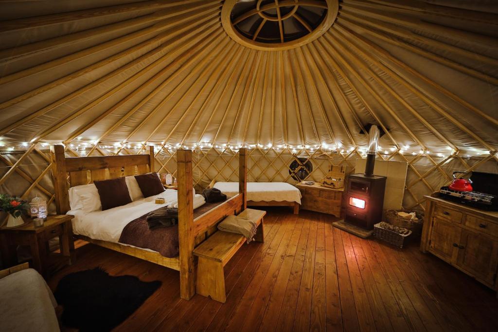 1 dormitorio en una yurta con cama y fogones en Secret Cloud House Holidays Luxury Yurts with Hot Tubs, en Cauldon