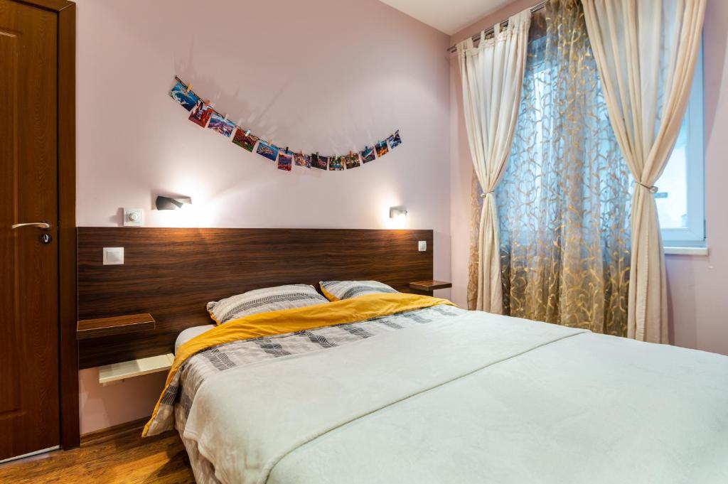a bedroom with a large bed and a window at ~ Colorful Dream Apartment ~ 2BD in the TOP Center of Sofia in Sofia