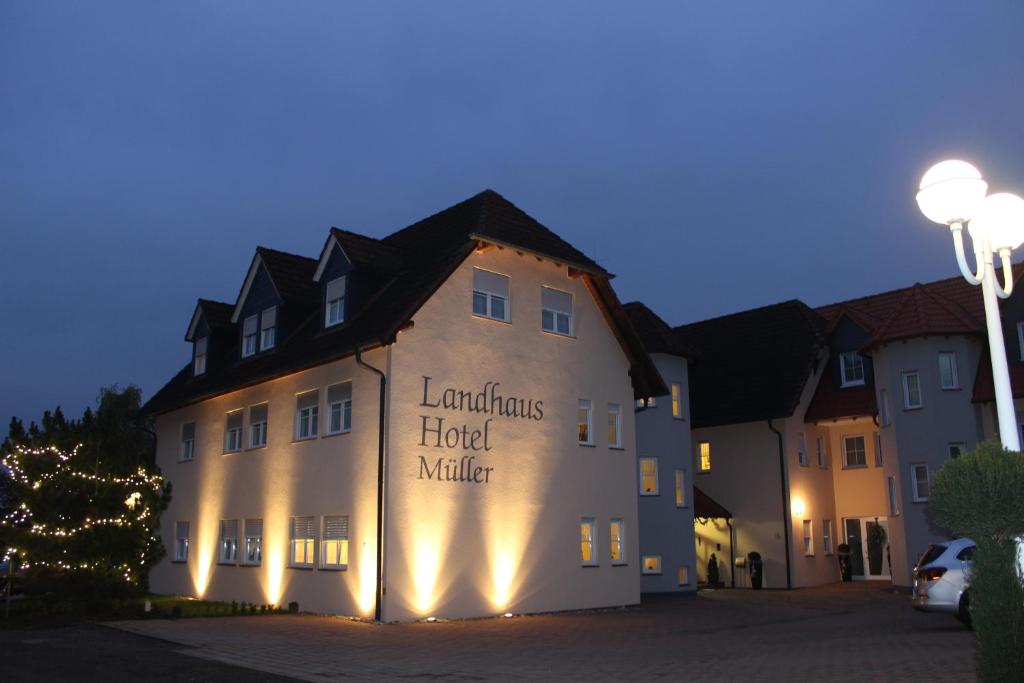 un hôtel avec des lumières sur le côté d'un bâtiment dans l'établissement Landhaus Hotel Müller, à Ringheim