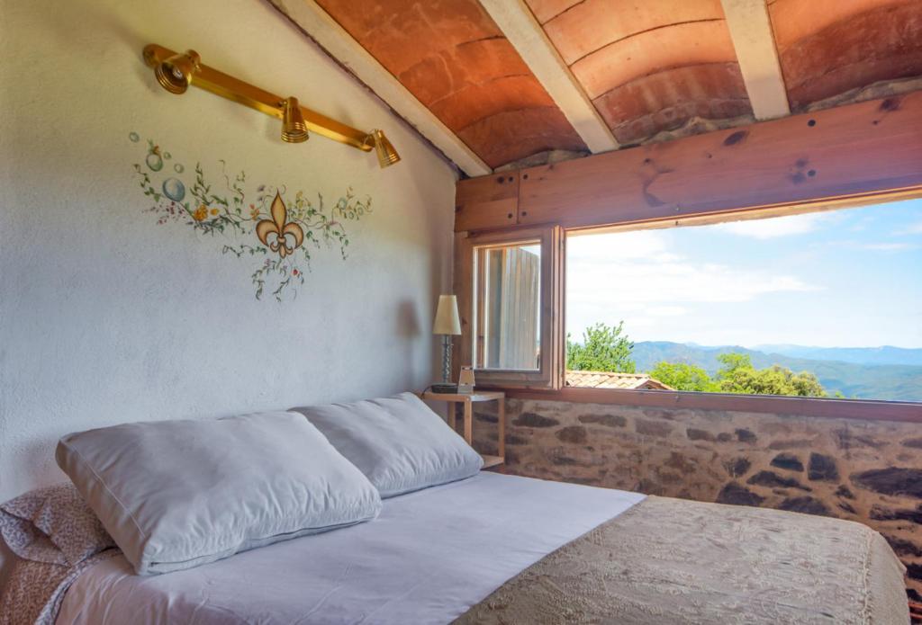 1 dormitorio con cama y ventana grande en Apartamento duplex rural con chimenea y vistas panorámicas desde la cama, en San Martín Sacalm