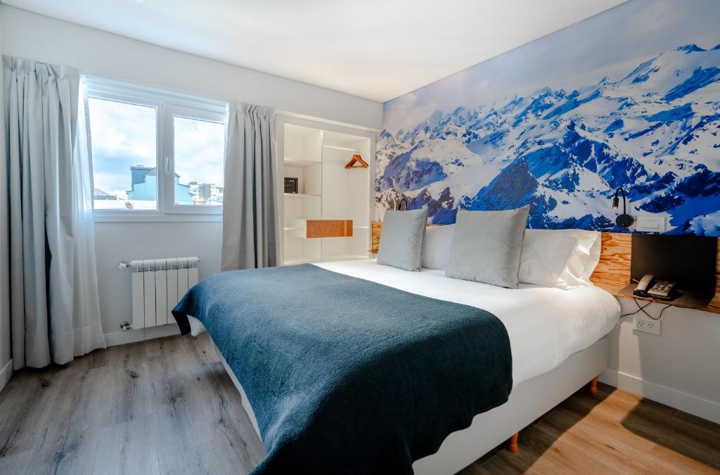 um quarto com uma cama grande e um mural de montanha em Cilene del Fuego Suites & Spa em Ushuaia