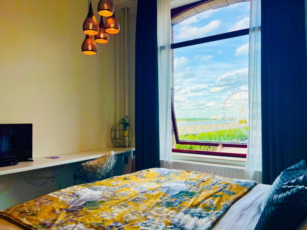 a bedroom with a window with a view of a wheel at Riverview Studio in Historical Heart of Antwerp in Antwerp