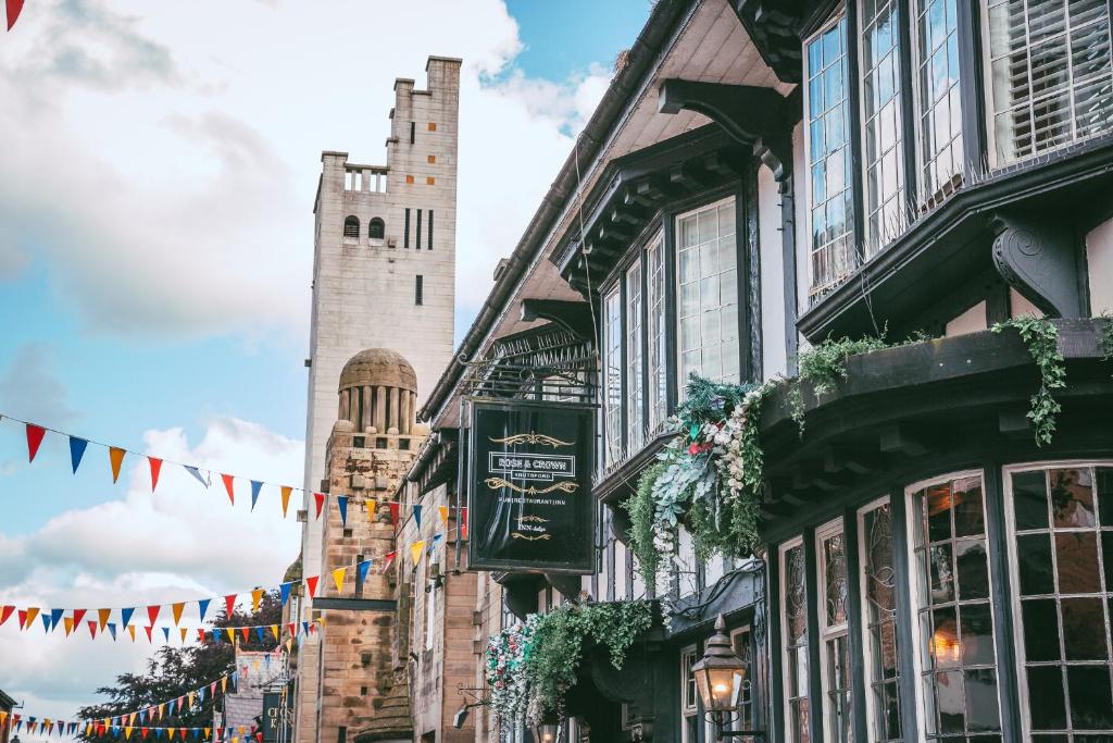 uma rua em frente a edifícios com bandeiras e uma torre em Rose & Crown Inn em Knutsford