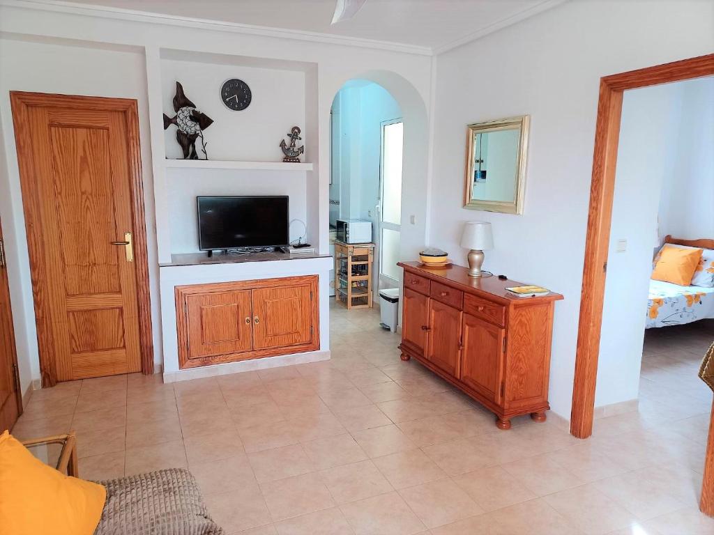 sala de estar con TV de pantalla plana y mesa en Molino Blanco Penthouse 15, en Playas de Orihuela