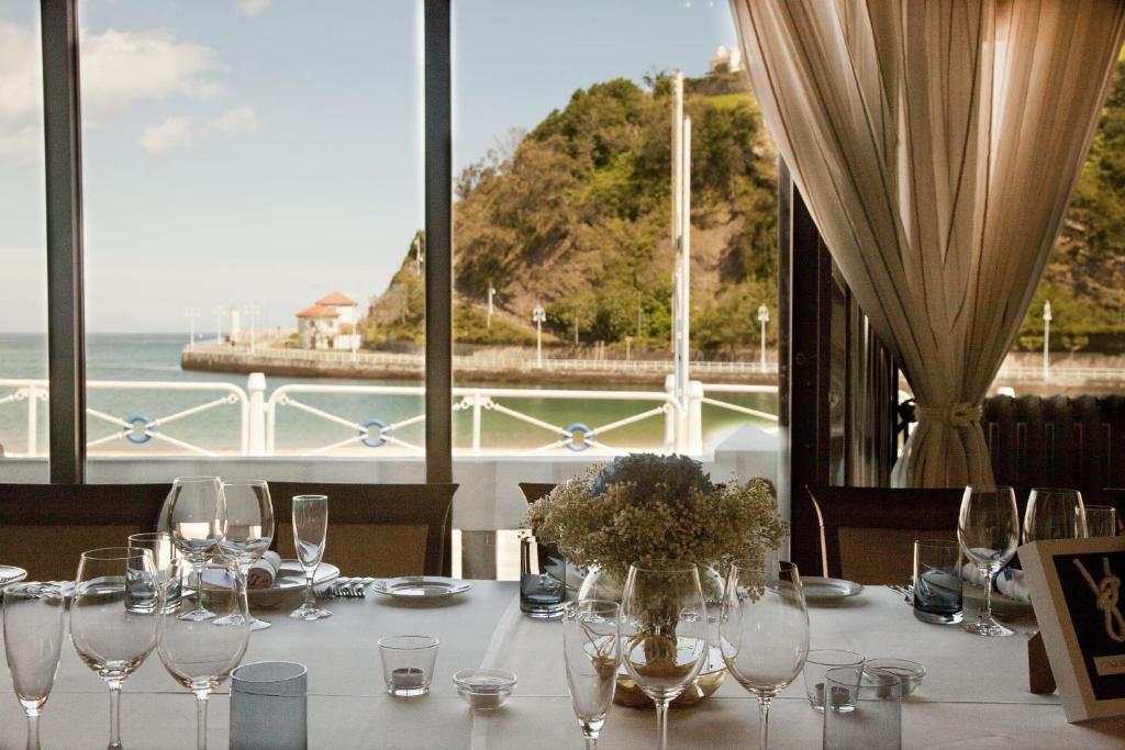 a table with wine glasses and a view of the ocean at Gran Hotel del Sella in Ribadesella