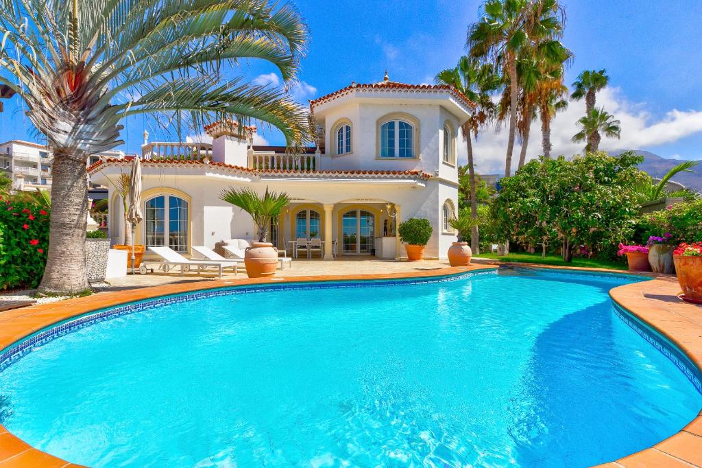 a large swimming pool in front of a house at Luxury villa El Duque Ocean View in Adeje