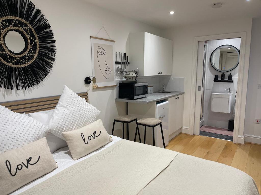 a bedroom with a white bed and a kitchen at The Hideaway in Kent
