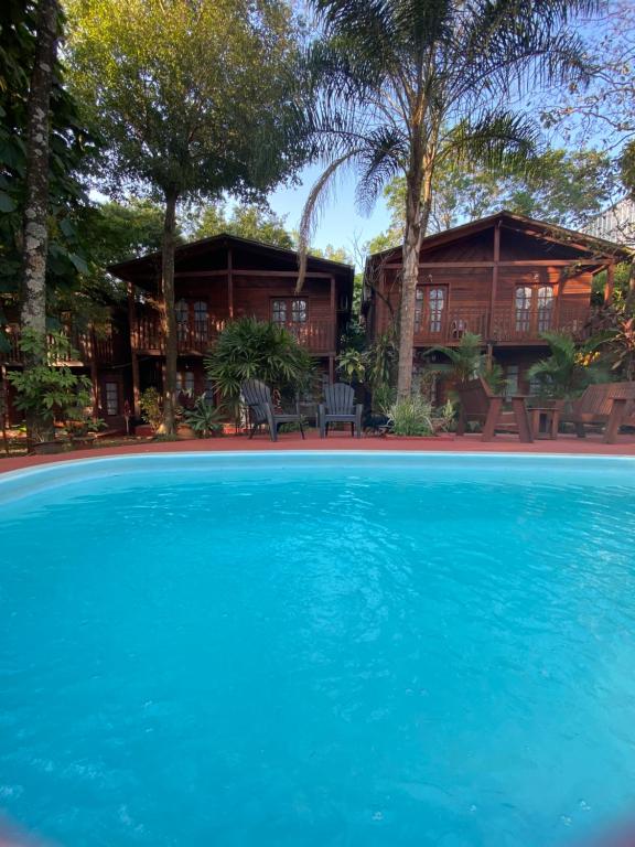 uma casa com uma grande piscina em frente em El Pindo Iguazu em Puerto Iguazú