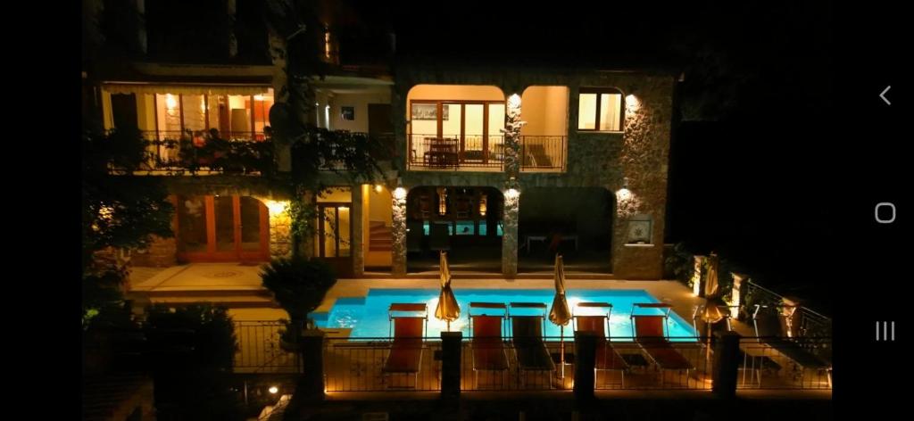 a swimming pool in front of a house at night at Apartments Villa Čučuk in Budva