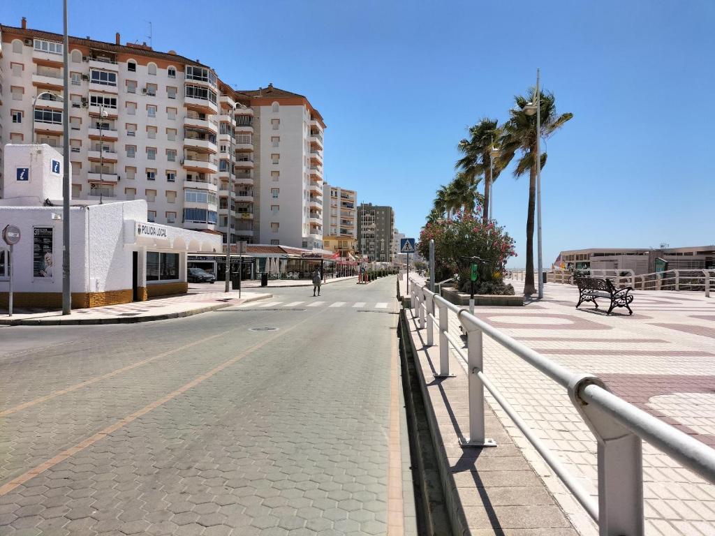 an empty city street with palm trees and buildings at Flamenco playa in El Puerto de Santa María