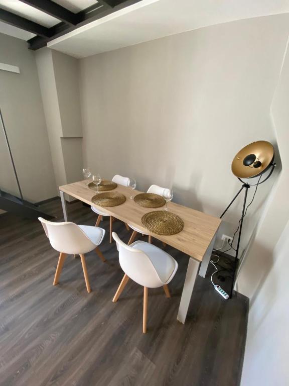 a dining room with a wooden table and white chairs at B&b Principe18 in Noci