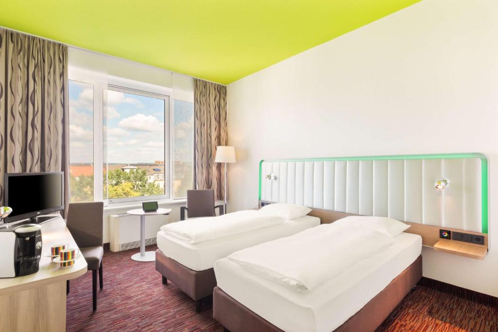 a hotel room with two beds and a television at Park Inn by Radisson Dresden in Dresden