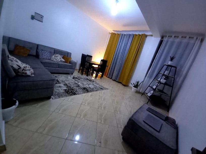 a living room with a couch and a chair at J&R - Lovely two bedroom apartment in Jinja. in Jinja