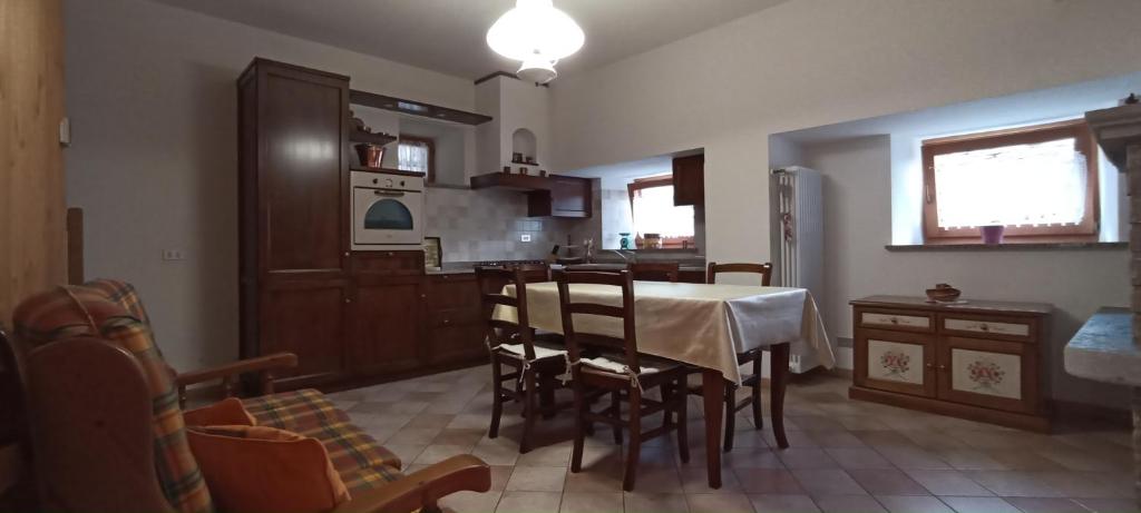 - une cuisine et une salle à manger avec une table et des chaises dans l'établissement Appartamento Tzendelabo, à Gaby