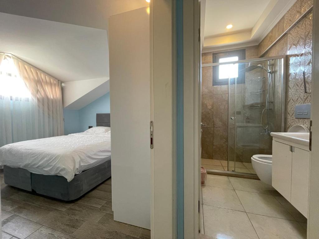 a bedroom with a bed and a bathroom with a shower at X SUITE APART in Fethiye