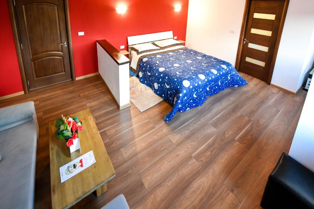 1 dormitorio con 1 cama y suelo de madera en Villa CASTELLINO, en Târgu Ocna